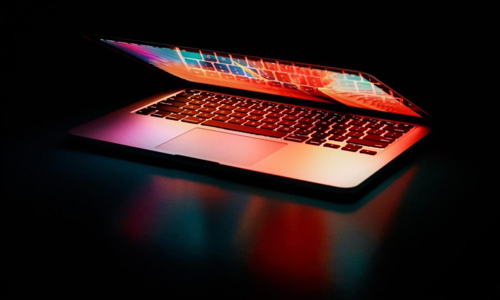 MacBook laptop with closed lid and keyboard reflecting colors